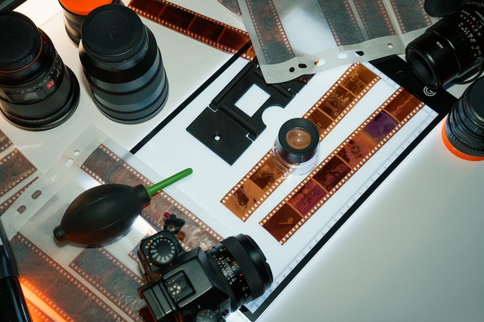 Studio shot showcasing professional film photography equipment including lenses, negatives, and inspection tools.
